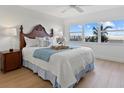 Comfortable bedroom featuring a queen bed, bedside tables, and ocean views from the window at 255 The Esplanade N # 106, Venice, FL 34285