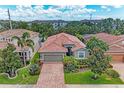Aerial view of a well-maintained home with a red tile roof, brick driveway, and mature landscaping at 2944 Oriole Dr, Sarasota, FL 34243