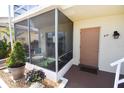 Inviting condo entrance with screen enclosed porch and unit 215 address at 320 Base E Ave # 215, Venice, FL 34285