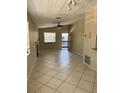 Spacious living room with neutral paint, tile floors, ceiling fan, and a door to a private screened porch at 3862 59Th W Ave # 4180, Bradenton, FL 34210