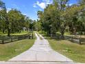 Long driveway leading to a house surrounded by lush greenery and trees at 3863 Albin Ave, North Port, FL 34286