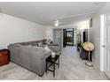 Inviting living room featuring a plush sectional sofa, neutral decor, and sliding doors to a screened lanai at 401 Airport E Ave # 304, Venice, FL 34285