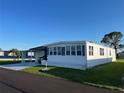 Low angle view of a charming single Gathering home with a covered driveway and tidy landscaping at 411 Vasto Dr, Venice, FL 34285