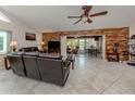 Spacious living room featuring tile flooring, a ceiling fan, and a wood-accent wall with a view to the dining room at 4176 Summertree Rd, Venice, FL 34293