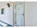 A clean, well-maintained front door of a condo unit, illuminated by an exterior light fixture at 437 Cerromar Ln # 513, Venice, FL 34293