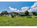 Well maintained exterior view of a home showing the manicured lawn, screened in porch, and lush landscaping at 48 Lark Dr, Placida, FL 33946