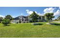 Exterior view of a house showing the screened in porch, lush lawn and landscaping at 48 Lark Dr, Placida, FL 33946