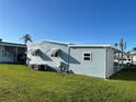 Side view of the home with blue siding, manicured lawn, and a convenient carport, offering a practical outdoor space at 529 Cervina S Dr, Venice, FL 34285
