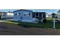 Well-maintained blue home featuring a cozy screened-in porch and manicured lawn, perfect for relaxing outdoors at 529 Cervina S Dr, Venice, FL 34285