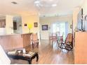 Open-concept living room featuring hardwood floors, a ceiling fan, and lots of natural light at 660 N Green Cir, Venice, FL 34285