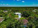Beautiful aerial view of a single-Gathering home nestled within a lush green landscape with mature trees surrounding the property at 6964 Glacier Ave, North Port, FL 34291