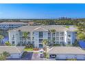 Beautiful exterior of building with manicured landscaping, carports, and lovely lake view at 700 Gardens Edge Dr # 722, Venice, FL 34285