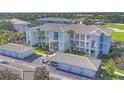 Aerial view of the building with well-maintained grounds and assigned parking spaces at 700 Gardens Edge Dr # 722, Venice, FL 34285