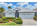 Inviting home with manicured landscaping and a paver driveway, featuring a secure front gate and attached two-car garage at 809 Derbyshire Dr, Venice, FL 34285