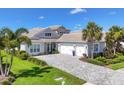 Attractive one-story home with a manicured lawn, paver driveway, and a convenient three-car garage at 8245 Grande Shores Dr, Sarasota, FL 34240