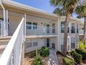 Condo featuring a private balcony with lush landscaping and access to outdoor amenities at 841 Waterside Dr # 202, Venice, FL 34285