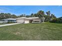 Well-maintained home with green lawn, palm tree, neutral exterior, and attached two-car garage at 903 E Shannon Ct, Venice, FL 34293