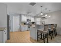 Bright kitchen with white cabinets, granite countertops, stainless appliances, and breakfast bar at 903 E Shannon Ct, Venice, FL 34293