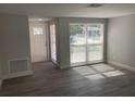 Bright living room with updated gray floors, neutral walls, and an abundance of natural light at 9110 Lunar Ln, Port Richey, FL 34668