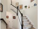Interior staircase with carpet runner and dark wood railings contrasted by light walls and decor at 935 Tidewater Shores # 721, Bradenton, FL 34208