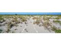 A beach access path shows natural dunes and vegetation along the path at 950 Tarpon Center Dr # 305, Venice, FL 34285