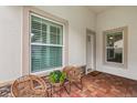 Inviting entryway featuring brick flooring, decorative chairs, and large windows with plantation shutters at 121 Colebrook Ct, Venice, FL 34292