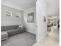 Comfortable living room with grey sofa and an open view of the kitchen and dining area at 121 Colebrook Ct, Venice, FL 34292
