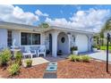 Close up of cozy front porch with seating and decorative landscaping details by the entrance at 1222 Pinebrook Way, Venice, FL 34285