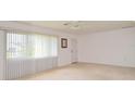 Bright living room with large window, neutral walls, plush carpeting, and a ceiling fan at 1290 Leeward Rd, Venice, FL 34293