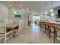 Open-concept living space with breakfast bar, dining table, and view of the living room and pool at 13862 Miranese St, Venice, FL 34293