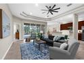 Bright open living area with tray ceiling, neutral tones, stylish furnishings and tile flooring at 2396 Caraway Dr, Venice, FL 34292