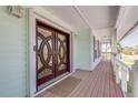 Inviting front entrance with detailed wood door, sidelights, and a spacious covered porch at 334 7Th N Ave, Tierra Verde, FL 33715