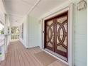 Inviting front entrance with detailed wood door, sidelights, and a spacious covered porch at 334 7Th N Ave, Tierra Verde, FL 33715