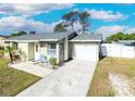 Lovely one-story home with a attached garage, gray roof, inviting entrance, and a neatly maintained lawn at 7585 Kavanda St, North Port, FL 34287