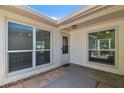 Covered front porch with exterior windows, brick accents and a white door at 7405 Clearview Dr, Tampa, FL 33634