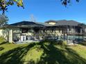 Backyard view featuring a screened-in pool, a patio, and lush green landscaping at 4250 Shamrock Dr, Venice, FL 34293