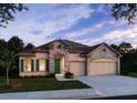 Charming single-story home with stone accents, a well-manicured lawn, and a two-car garage with a sidewalk at 25497 Calusa Dr, Punta Gorda, FL 33955