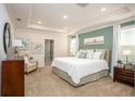 Spacious main bedroom features tray ceiling, ensuite bath, and carpeted flooring at 25129 Calusa Dr, Punta Gorda, FL 33955