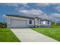 Driveway and well-manicured lawn lead to a contemporary single Gathering home with an attached garage at 15245 Brainbridge Circle, Port Charlotte, FL 33981