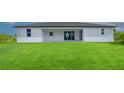 Home's back features a covered patio and large backyard at 15245 Brainbridge Circle, Port Charlotte, FL 33981