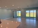 Bright, open living room with tile flooring, recessed lighting, and sliding glass doors to the backyard at 25491 Calusa Dr, Punta Gorda, FL 33955