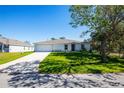 Newly built home with a white exterior, attached garage, and a landscaped yard at 4220 Joseph St, Port Charlotte, FL 33948