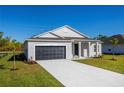 New construction home with gray siding, black garage door and a paved driveway at 25372 Alicante Dr, Punta Gorda, FL 33955