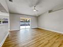 Bright living room with wood-look floors and sliding doors to backyard at 865 Everest Rd, Venice, FL 34293