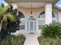Inviting front entrance with arched windows and landscaping at 1 Long Meadow Ln, Rotonda West, FL 33947