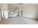 Spacious living room with light-colored carpet and kitchen at 8235 Amendola Ave, North Port, FL 34291
