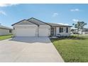 Two-car garage, gray siding, and landscaping at 14074 Ginnie Springs Way, Parrish, FL 34219