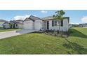 Two-car garage, gray siding, and landscaping at 14074 Ginnie Springs Way, Parrish, FL 34219