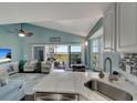 Open concept living area with view from kitchen, featuring beachy decor and access to the porch at 7442 Palm Island Dr # 3624, Placida, FL 33946