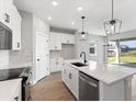 Modern kitchen with white cabinets, quartz countertops and island, overlooking a lake at 507 Sun Chaser Dr, Nokomis, FL 34275